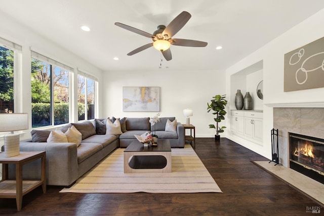 living room featuring recessed lighting, a tiled fireplace, ceiling fan, wood finished floors, and baseboards