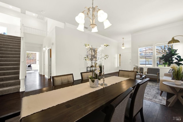 dining area featuring crown molding, a healthy amount of sunlight, dark wood finished floors, and stairs