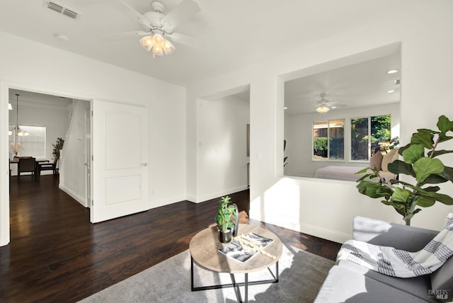 living area featuring visible vents, dark wood finished floors, baseboards, ceiling fan with notable chandelier, and recessed lighting