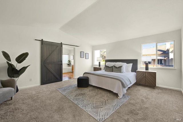 carpeted bedroom featuring vaulted ceiling, a barn door, and baseboards