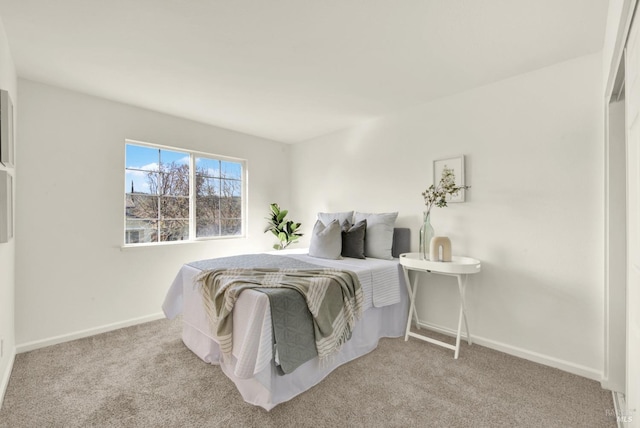 bedroom featuring light colored carpet and baseboards