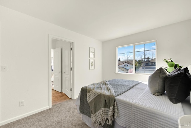 bedroom featuring light colored carpet and baseboards