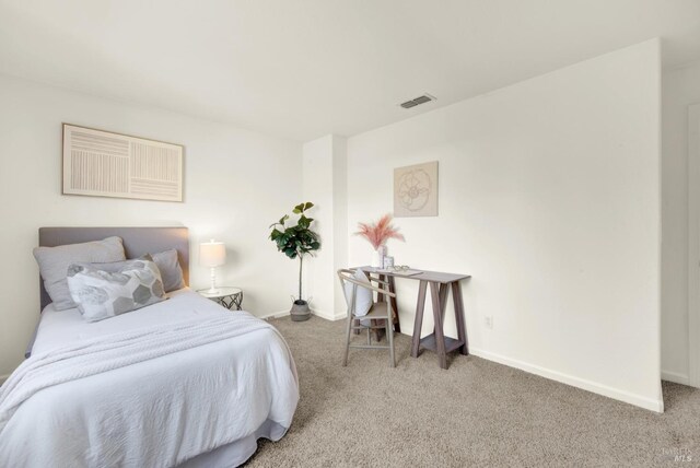 carpeted bedroom with visible vents and baseboards