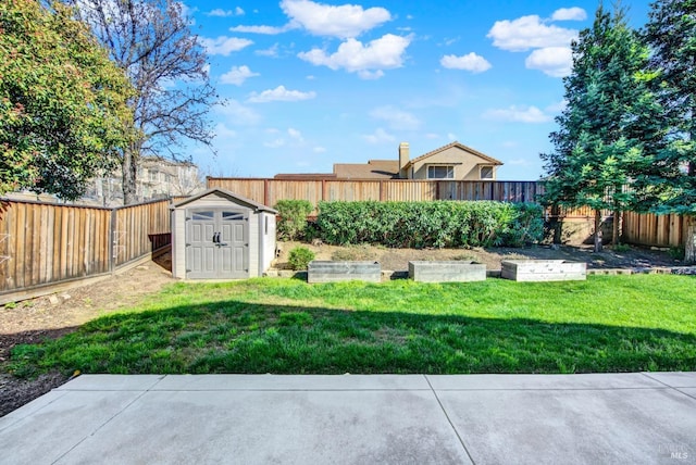 view of yard with a vegetable garden, a fenced backyard, an outdoor structure, and a shed