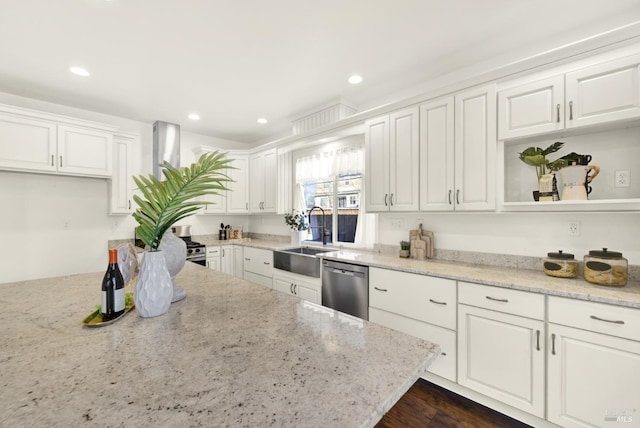 kitchen with a sink, white cabinetry, light stone counters, and stainless steel dishwasher