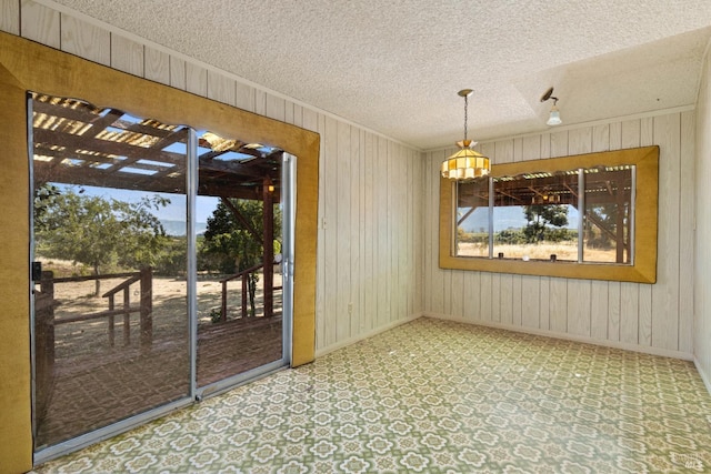 1579 Leslie Ln, Kelseyville, CA 95451 - unfurnished dining area featuring a textured ceiling, wood walls, a chandelier, baseboards, and crown molding