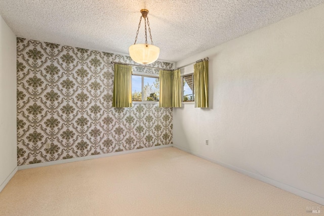 spare room with carpet floors, wallpapered walls, baseboards, and a textured ceiling