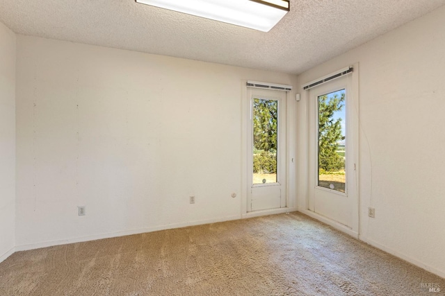 carpeted spare room with a textured ceiling