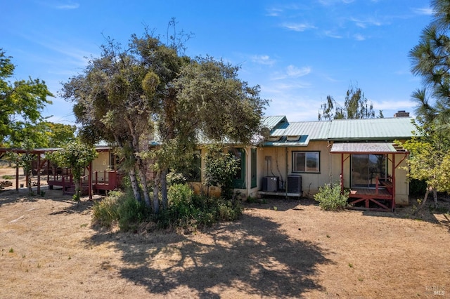 rear view of property featuring metal roof and cooling unit