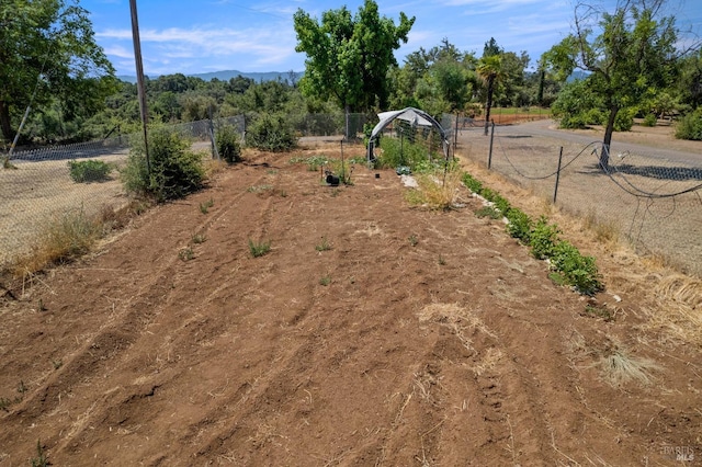 view of yard with fence and a rural view