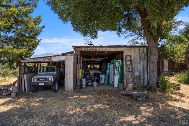 view of pole building with a carport and driveway