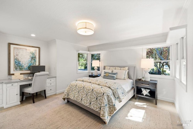 bedroom featuring crown molding, light wood finished floors, and baseboards