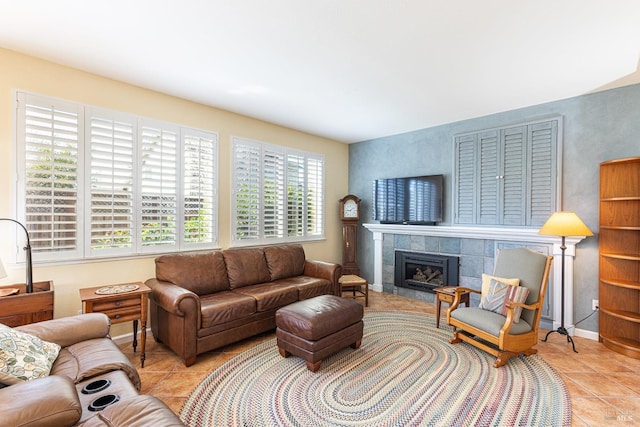 living area featuring light tile patterned floors, baseboards, and a tile fireplace