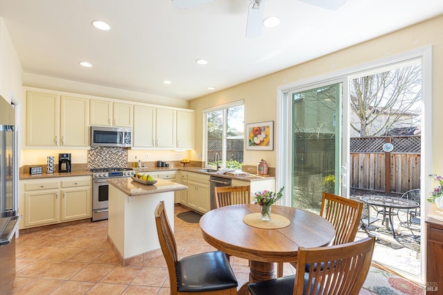 kitchen with light tile patterned floors, decorative backsplash, a kitchen island, stainless steel appliances, and recessed lighting