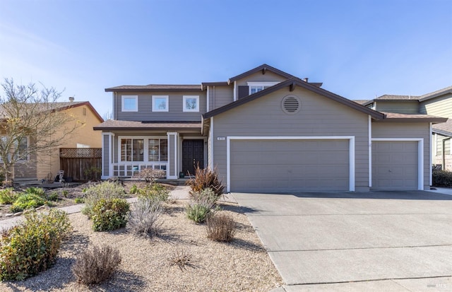 traditional-style home with driveway, an attached garage, and fence