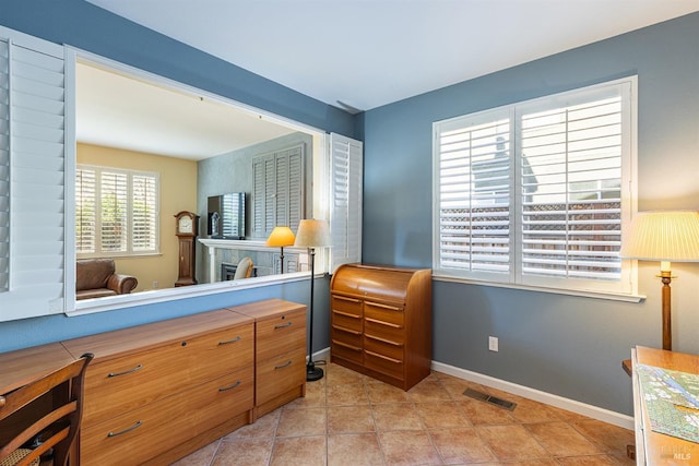 bedroom featuring light tile patterned floors, visible vents, and baseboards