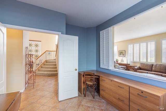 interior space with built in desk and light tile patterned floors