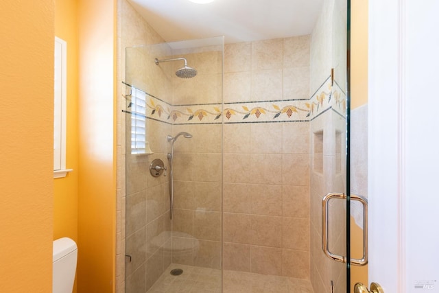 bathroom featuring a stall shower and toilet