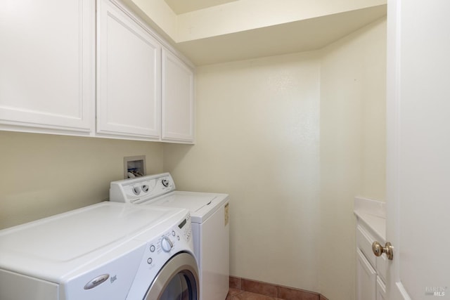 clothes washing area with washing machine and dryer, tile patterned flooring, and cabinet space