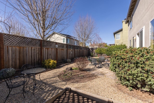 view of yard with outdoor dining space, a patio area, and a fenced backyard