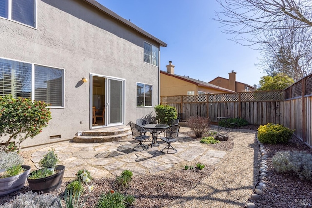 rear view of property with crawl space, a patio area, a fenced backyard, and stucco siding