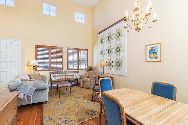 dining space featuring a chandelier, a high ceiling, and wood finished floors