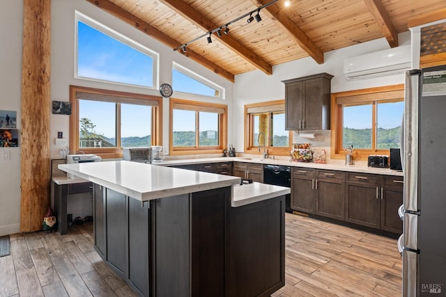 kitchen featuring light countertops, freestanding refrigerator, a kitchen island, a mountain view, and wooden ceiling