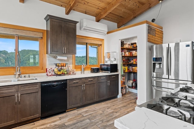 kitchen featuring dark brown cabinetry, a sink, black dishwasher, a wall mounted air conditioner, and stainless steel fridge