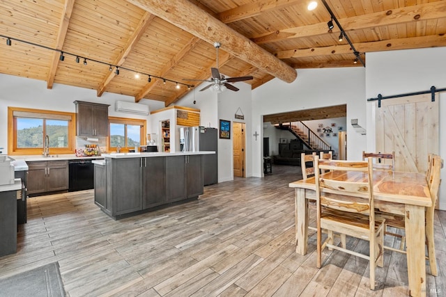 kitchen featuring a barn door, dishwasher, a center island, light countertops, and dark brown cabinets