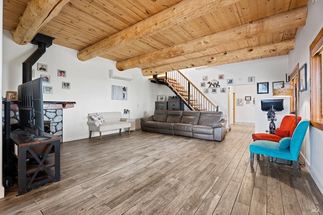 living room with a wood stove, a wall unit AC, wooden ceiling, and stairway