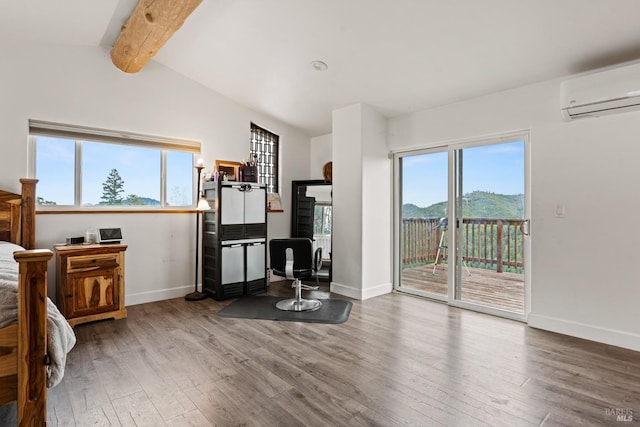 bedroom featuring access to outside, a mountain view, an AC wall unit, and wood finished floors