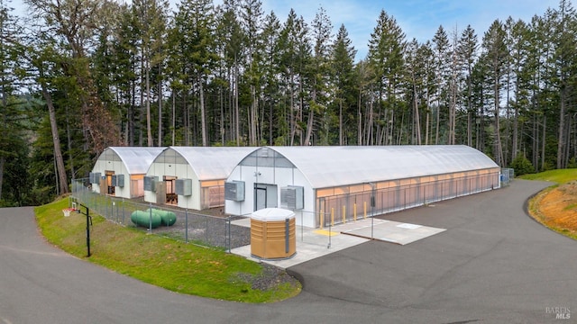 view of front facade with a view of trees and an outbuilding