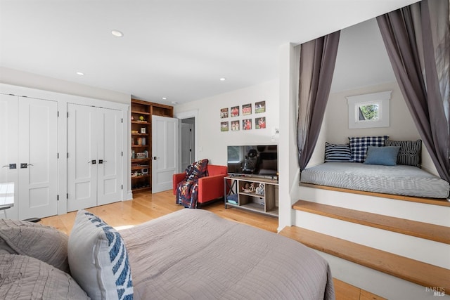 bedroom featuring two closets, light wood-style flooring, and recessed lighting