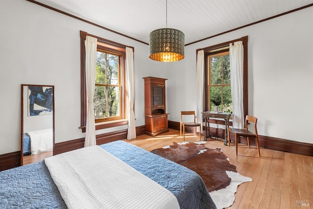 bedroom with ornamental molding, a chandelier, baseboards, and light wood finished floors