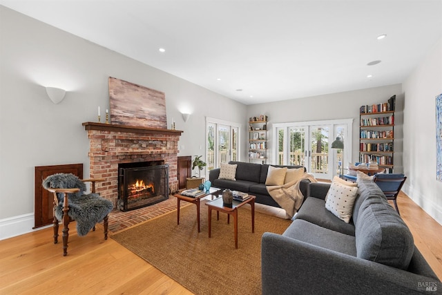 living area featuring light wood finished floors, a fireplace, and recessed lighting