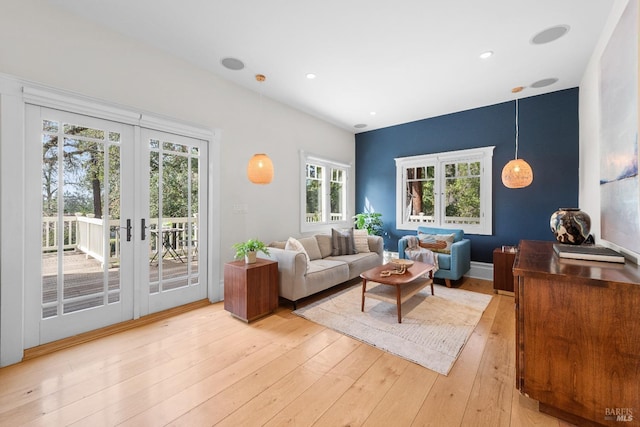 living room with french doors, light wood-type flooring, and recessed lighting