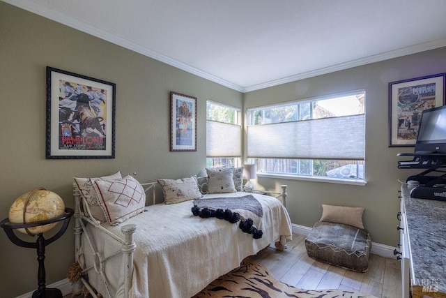 bedroom with ornamental molding, wood finished floors, and baseboards