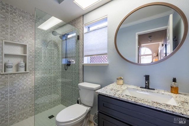 full bathroom featuring crown molding, vanity, toilet, and walk in shower