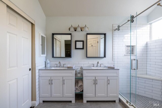 full bathroom with tile patterned flooring, a shower stall, vanity, and tile walls