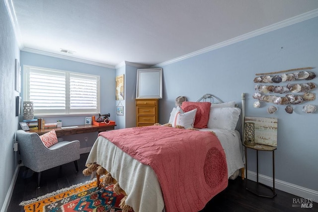 bedroom featuring ornamental molding, wood finished floors, visible vents, and baseboards