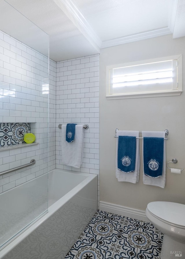 bathroom featuring shower / washtub combination, toilet, ornamental molding, baseboards, and tile patterned floors