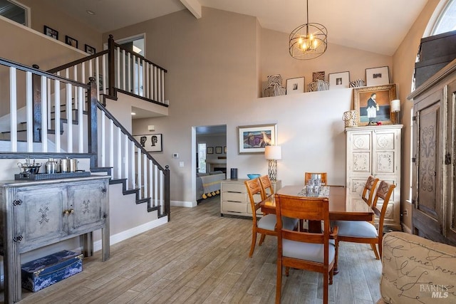 dining area featuring stairs, beamed ceiling, wood finished floors, and baseboards