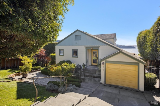 view of front of home with an attached garage, fence, concrete driveway, and a front yard