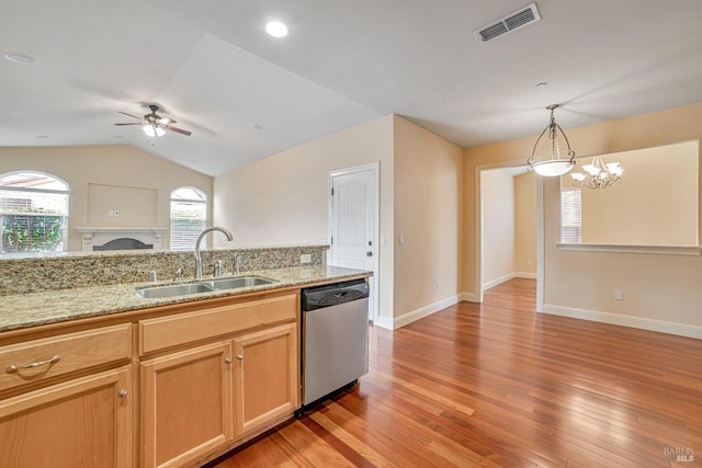 kitchen with visible vents, hanging light fixtures, open floor plan, a sink, and dishwasher