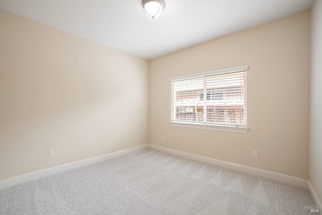 empty room featuring carpet floors and baseboards