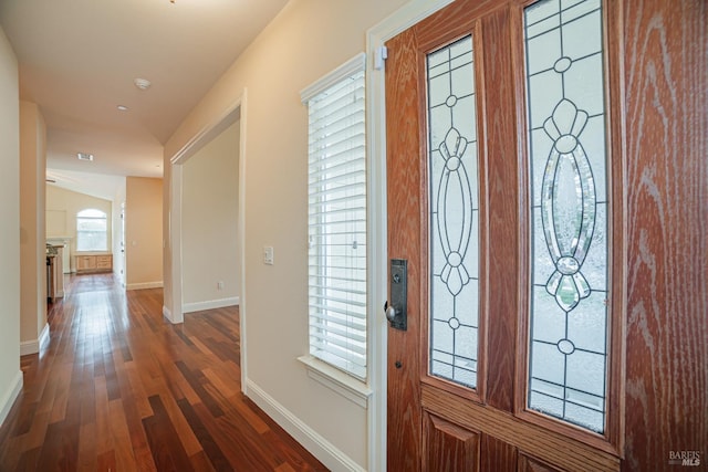 foyer entrance with dark wood-style floors and baseboards