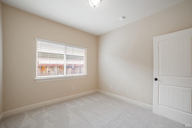 spare room with light carpet and baseboards