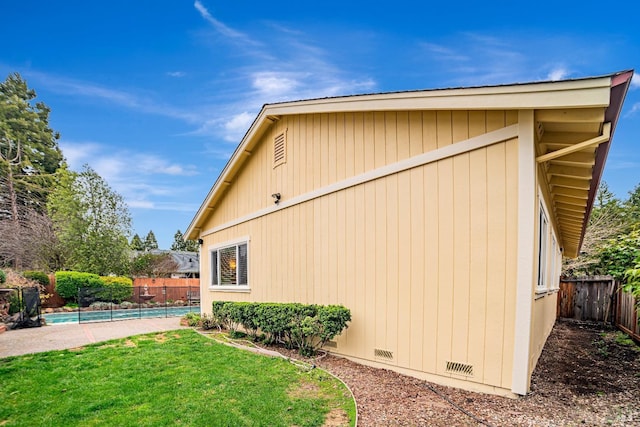 view of home's exterior with a yard, crawl space, a fenced backyard, and a fenced in pool