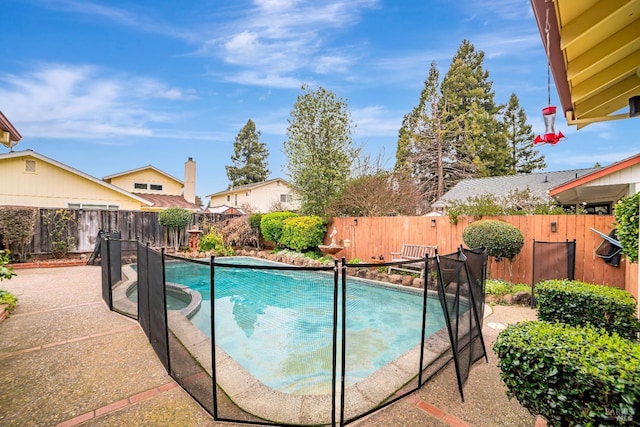 view of swimming pool with a fenced backyard and a pool with connected hot tub