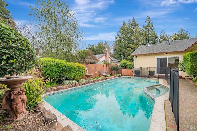 view of swimming pool featuring a pool with connected hot tub and a fenced backyard